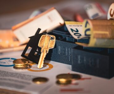 Close-up shot of a magnifying glass hovering over a document, symbolizing the scrutiny of a real estate contract, with hou...