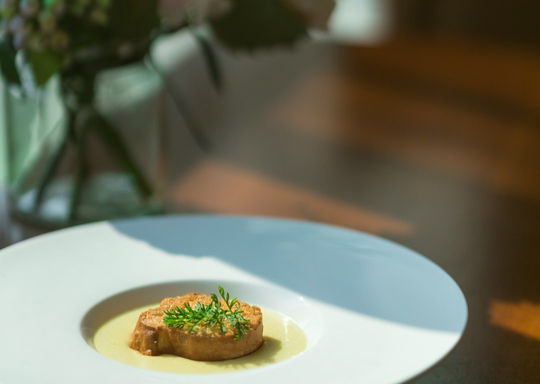 Close-up of a beautifully plated gourmet meal on a dark plate, representing an expensive dinner at a high-end restaurant.